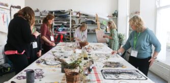 People around a table take part in a creative workshop.