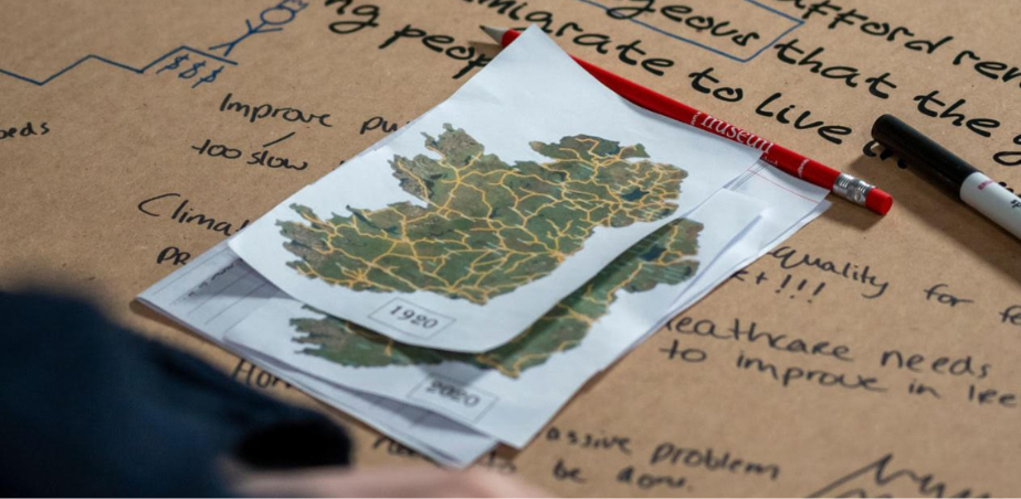 A stack of printouts with a map of Ireland from 1920 and other years sit on a surface with excerpts of text on it.