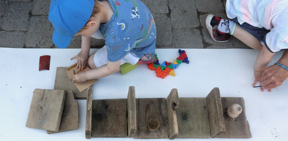 Children play with wood shapes for the launch of Principles for Engaging with the Arts