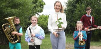 Minister McEntee stands with a group of children with musical instruments