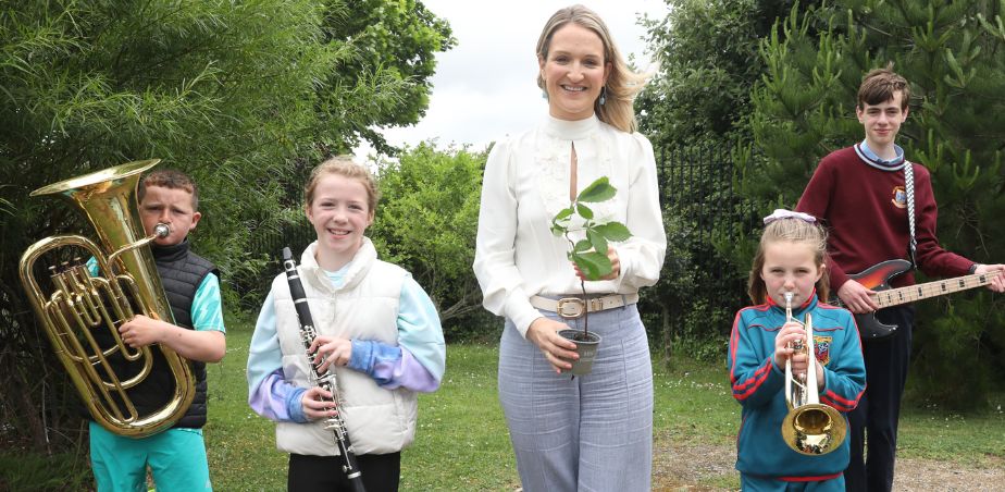 Minister McEntee stands with a group of children with musical instruments
