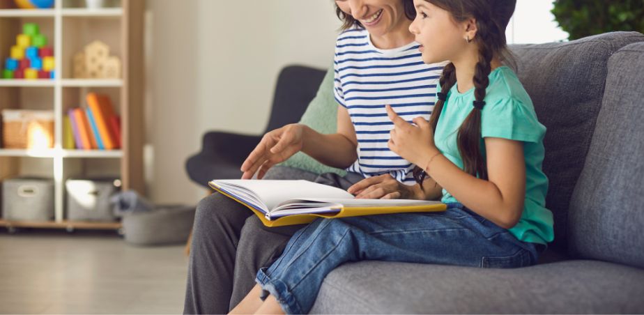 Mother and daughter sit on a sofa reading together - Blog 3 Dr Claire Dunne