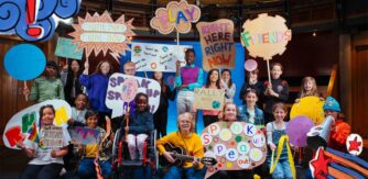 A group of children from the Arks Childrens council holding colourful placards