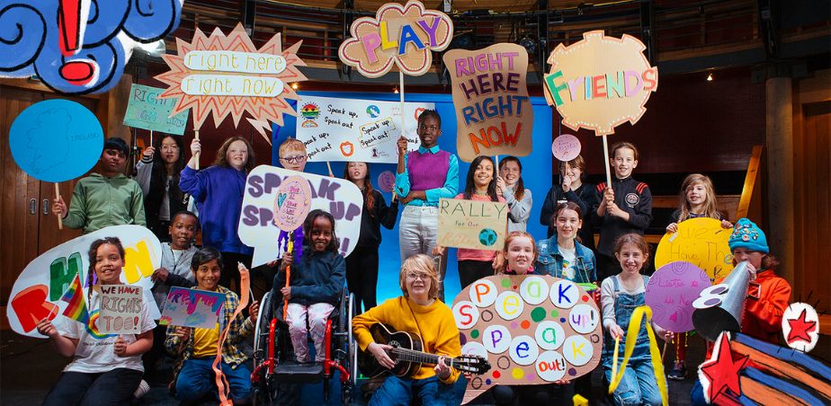 A group of children from the Arks Childrens council holding colourful placards
